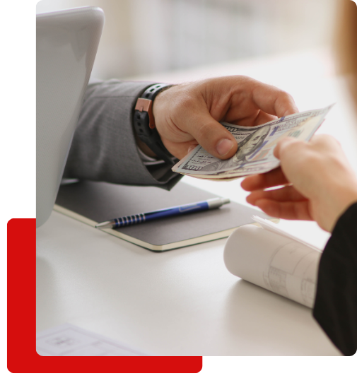 3 personal injury lawyer Handing a stack of hundred-dollar bills to another person.