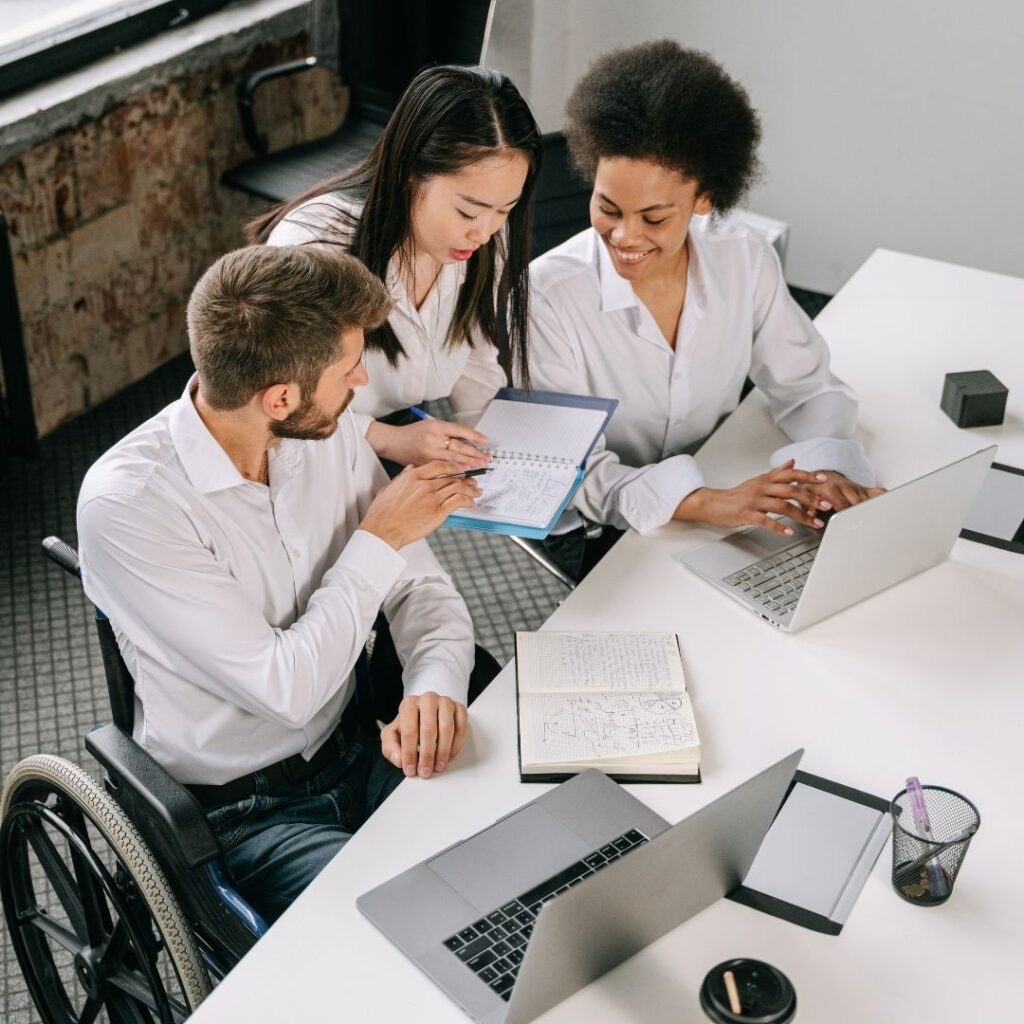 employees working on a project, including one employee in a wheelchair