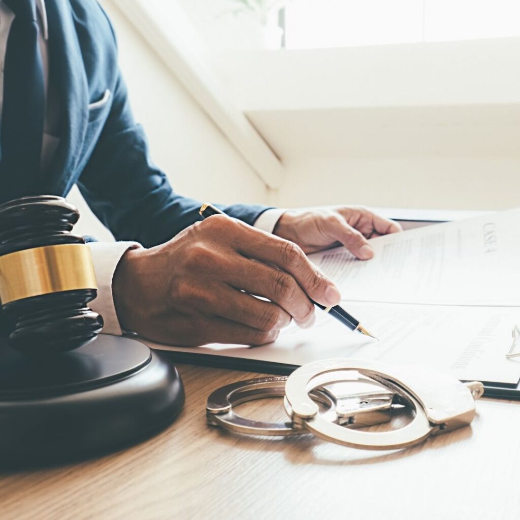 attorney looking through paperwork with handcuffs right next to it