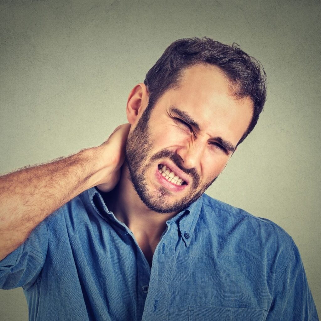 a man rubbing his neck in pain